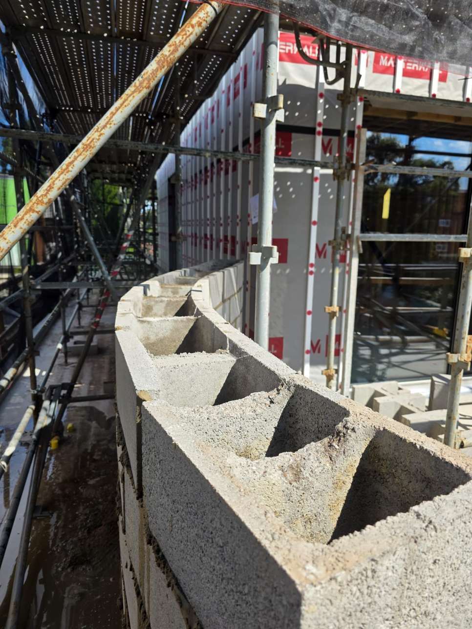 Besser blocks with open cores on top of a garage wall at scaffold level, garage blockwork, Melbourne