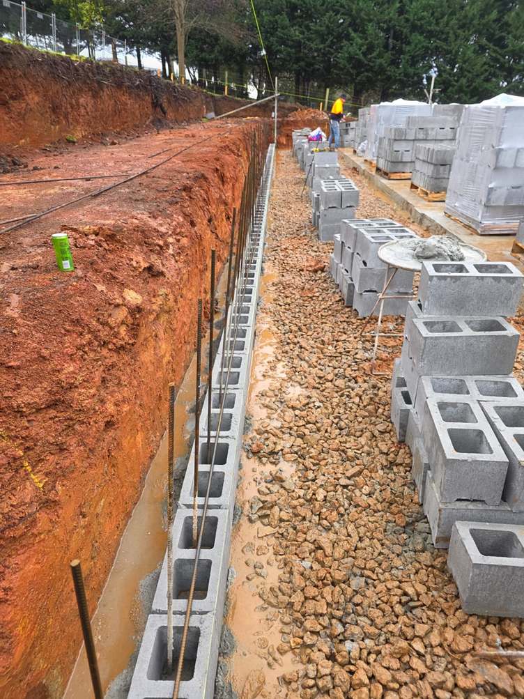 Block retaining wall base courses with steel starter bars and drainage gravel, core-filled retaining wall, Melbourne