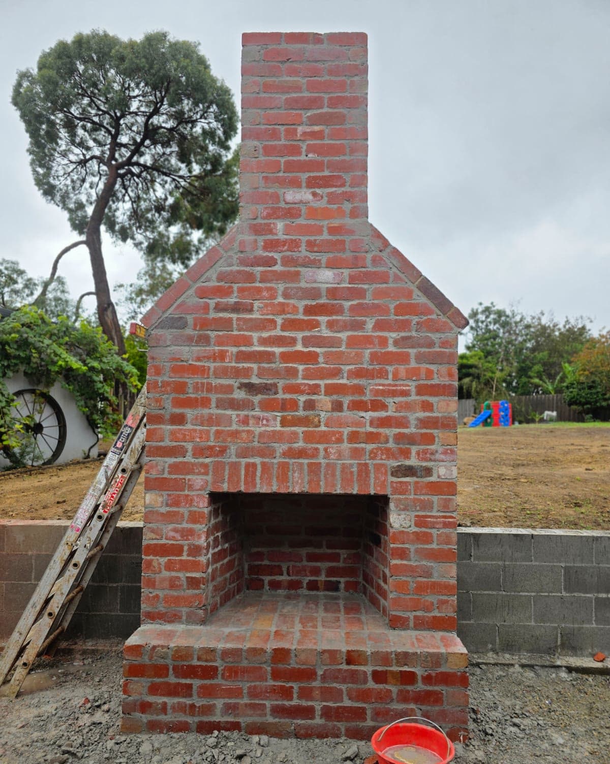 rendered outdoor fireplace with timber mantel — JC Brick & Blocklaying — bricklayer Melbourne eastern suburbs
