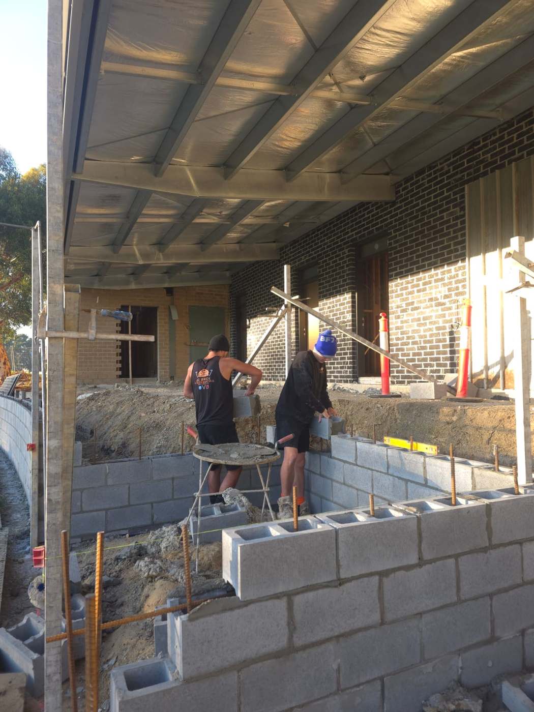 Blocklayers building a block wall at the rear of a house, garage and extension blockwork, Melbourne